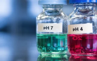 pH 7 (green) and 4 buffer (red) solutions in glass bottles.